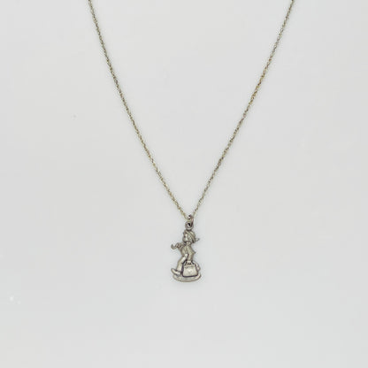 Flat lay of silver Hummel pendant necklace with twist chain