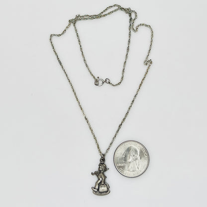 Flat lay of silver Hummel pendant necklace with twist chain