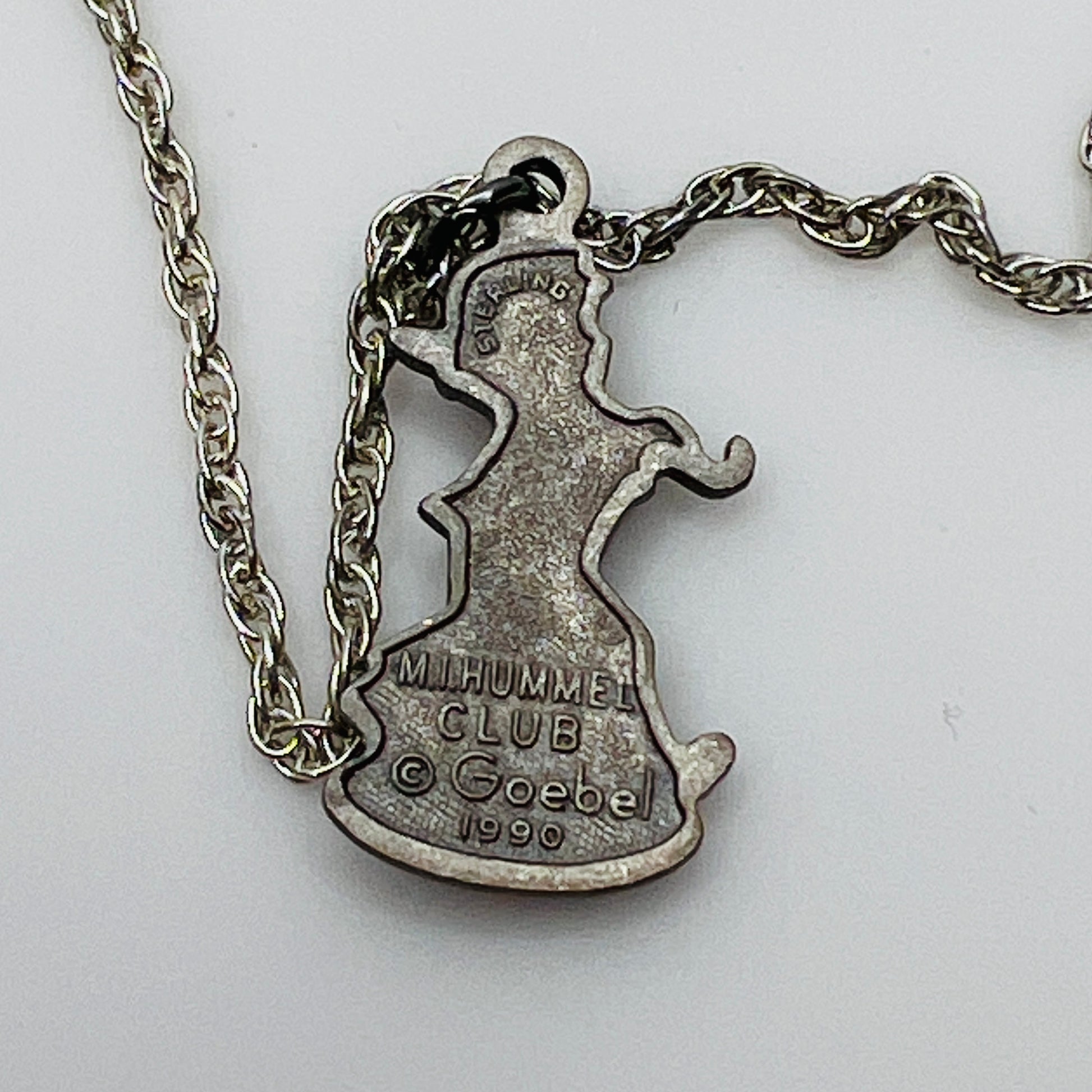 Back view Flat lay of silver Hummel pendant necklace with twist chain
