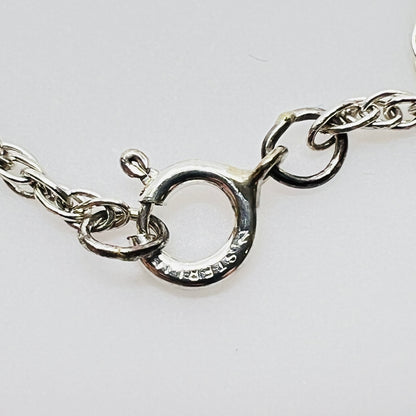 Clasp view Flat lay of silver Hummel pendant necklace with twist chain showing sterling stamp