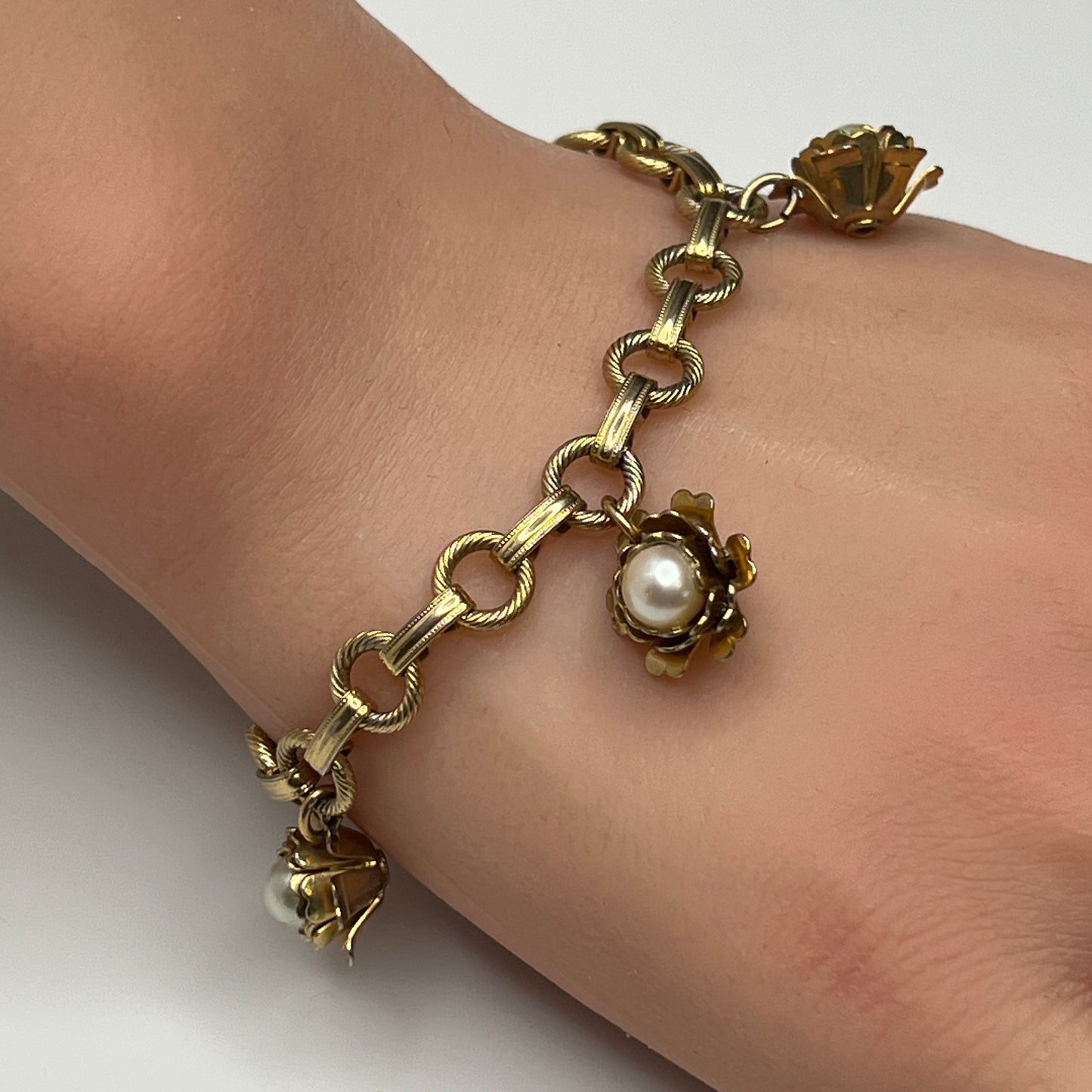 Close-up of rose-shaped charms with faux pearls on 1950s bracelet