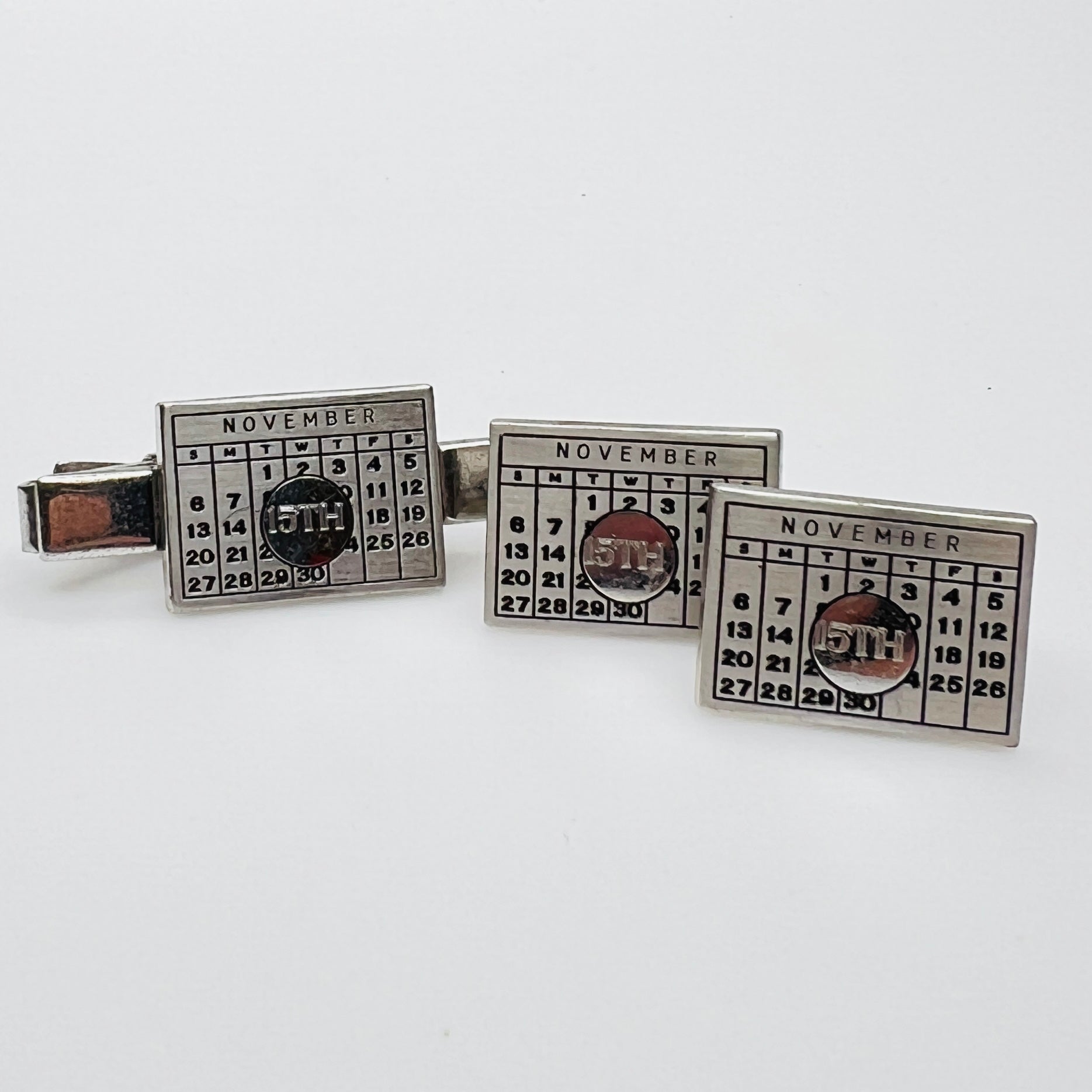 Close-up of cufflinks and tie bar showing November 15th detail