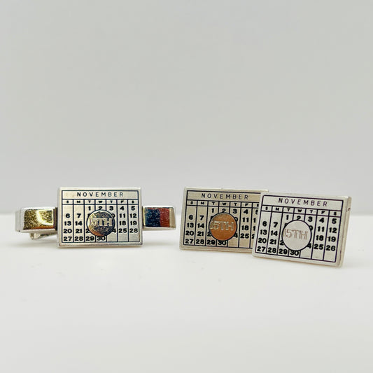 Close-up of cufflinks and tie bar showing November 15th detail
