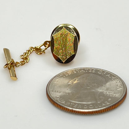 Close-up of monogrammed “M” cufflinks and matching gold-tone tie tack