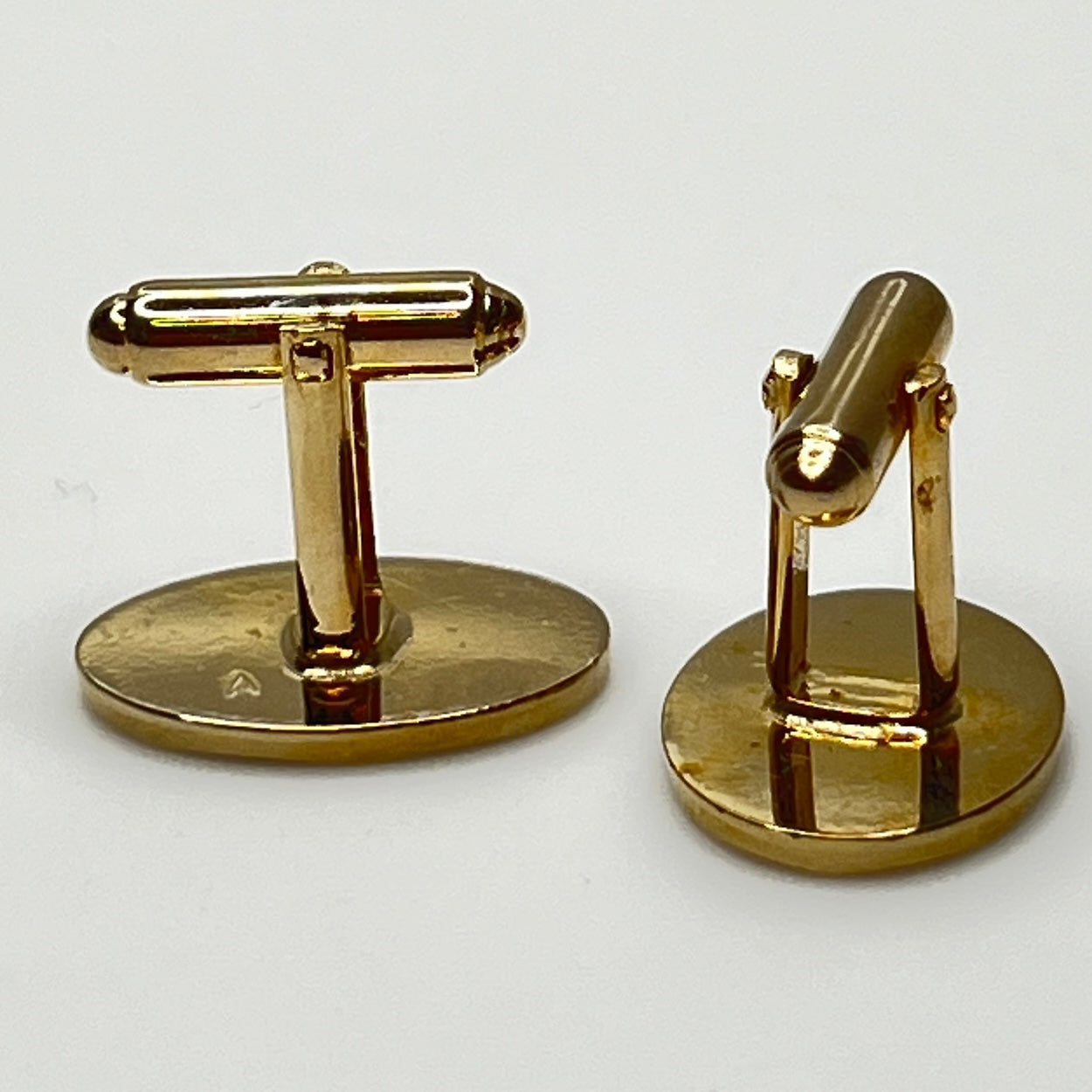 Close-up of monogrammed “M” cufflinks and matching gold-tone tie tack