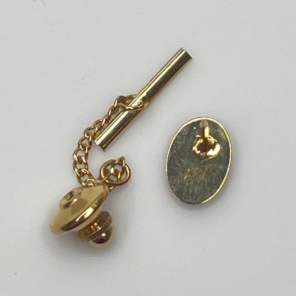 Close-up of monogrammed “M” cufflinks and matching gold-tone tie tack