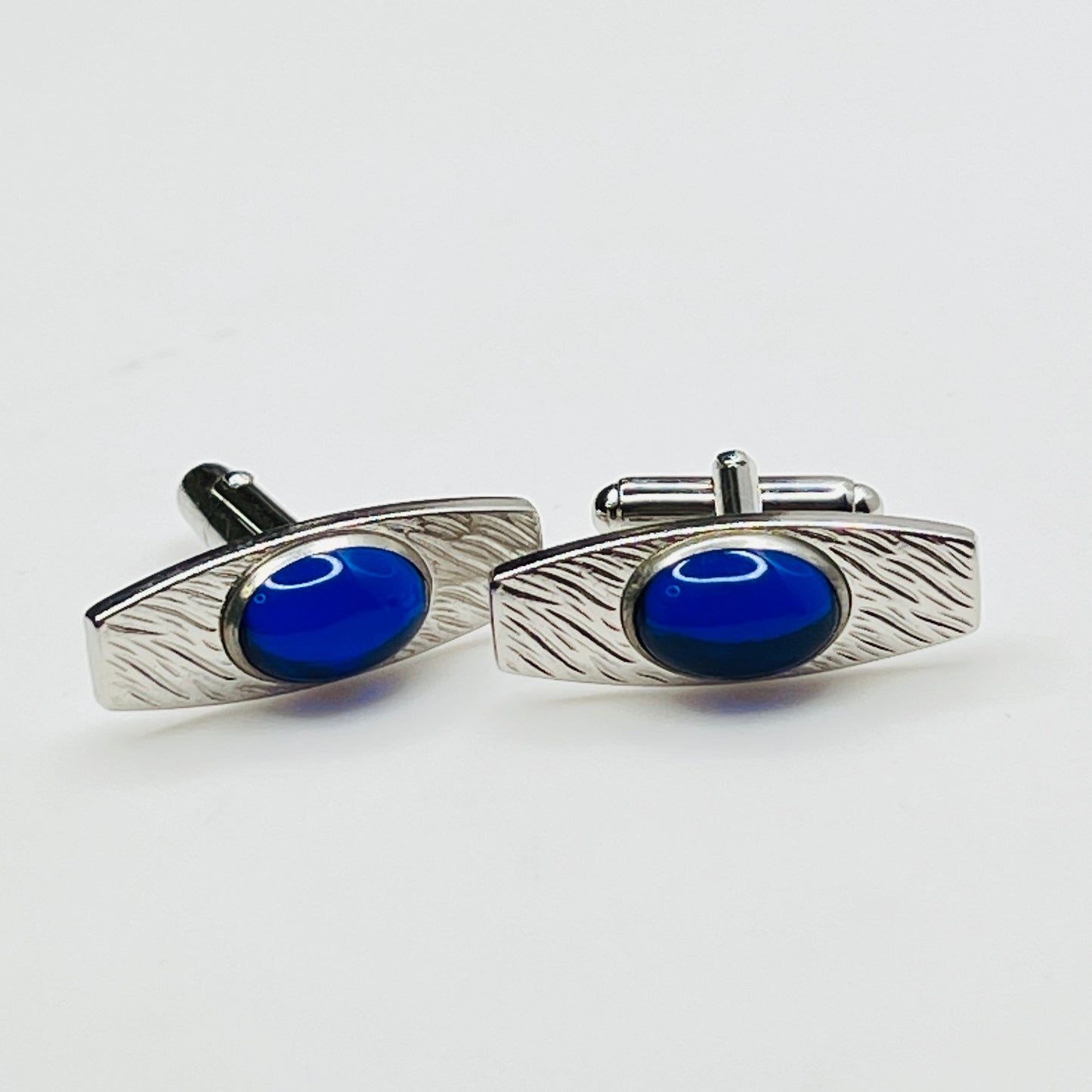Silver-tone cufflinks with textured finish and vivid blue lucite cabochons, signed Anson