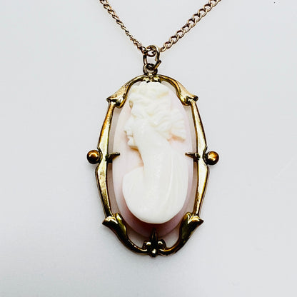 Close-up carved shell cameo female profile pink background