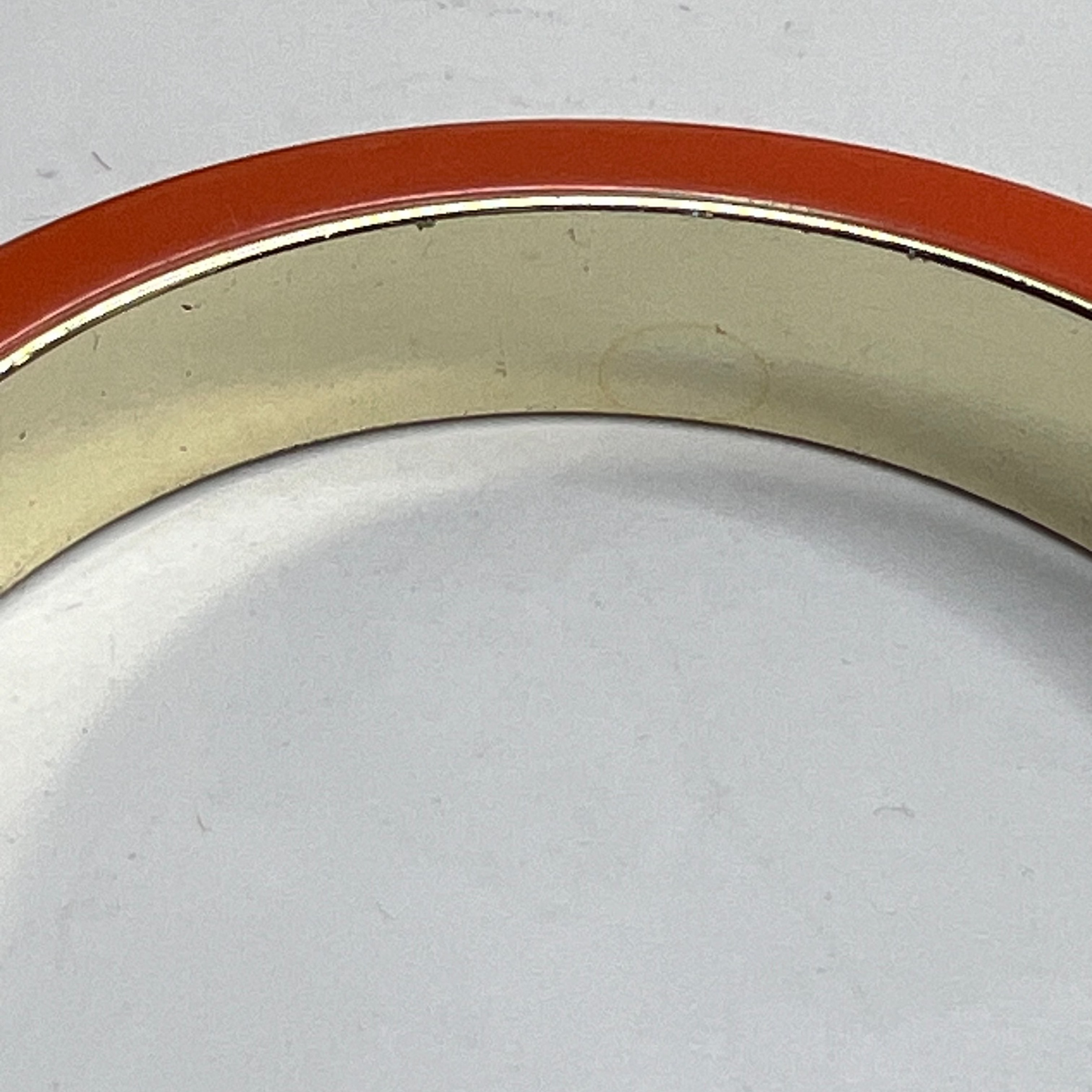 Orange Bakelite bangle bracelet with black stripe and gold-tone interior