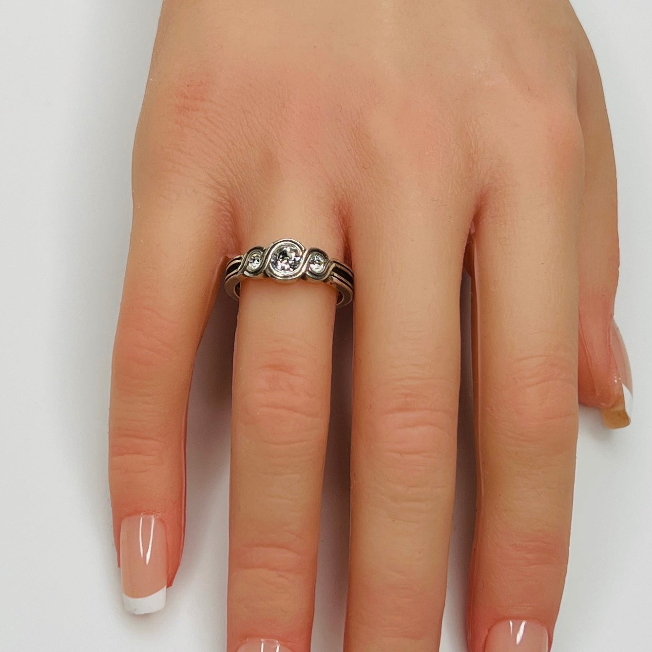 Sterling silver Brighton Infinity ring on hand with three bezel-set crystals
