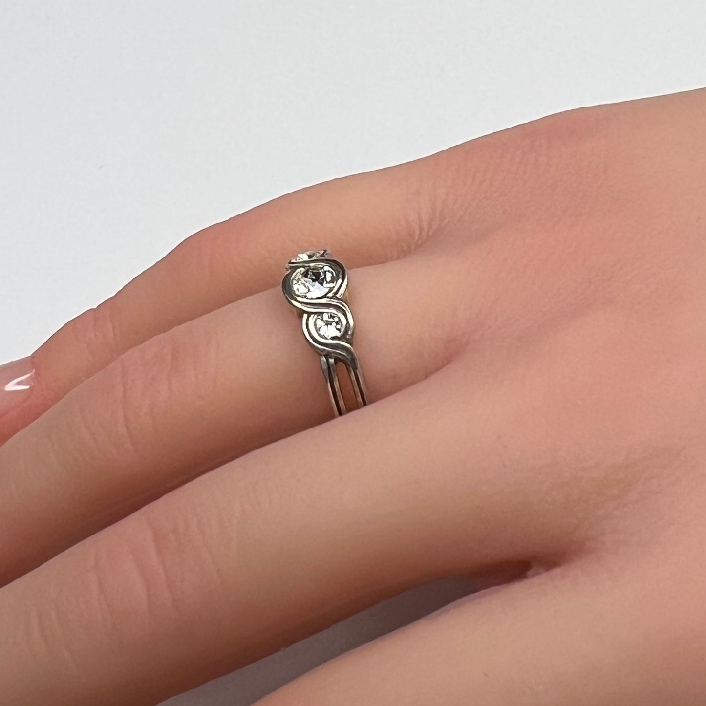 Sterling silver Brighton Infinity ring on hand with three bezel-set crystals