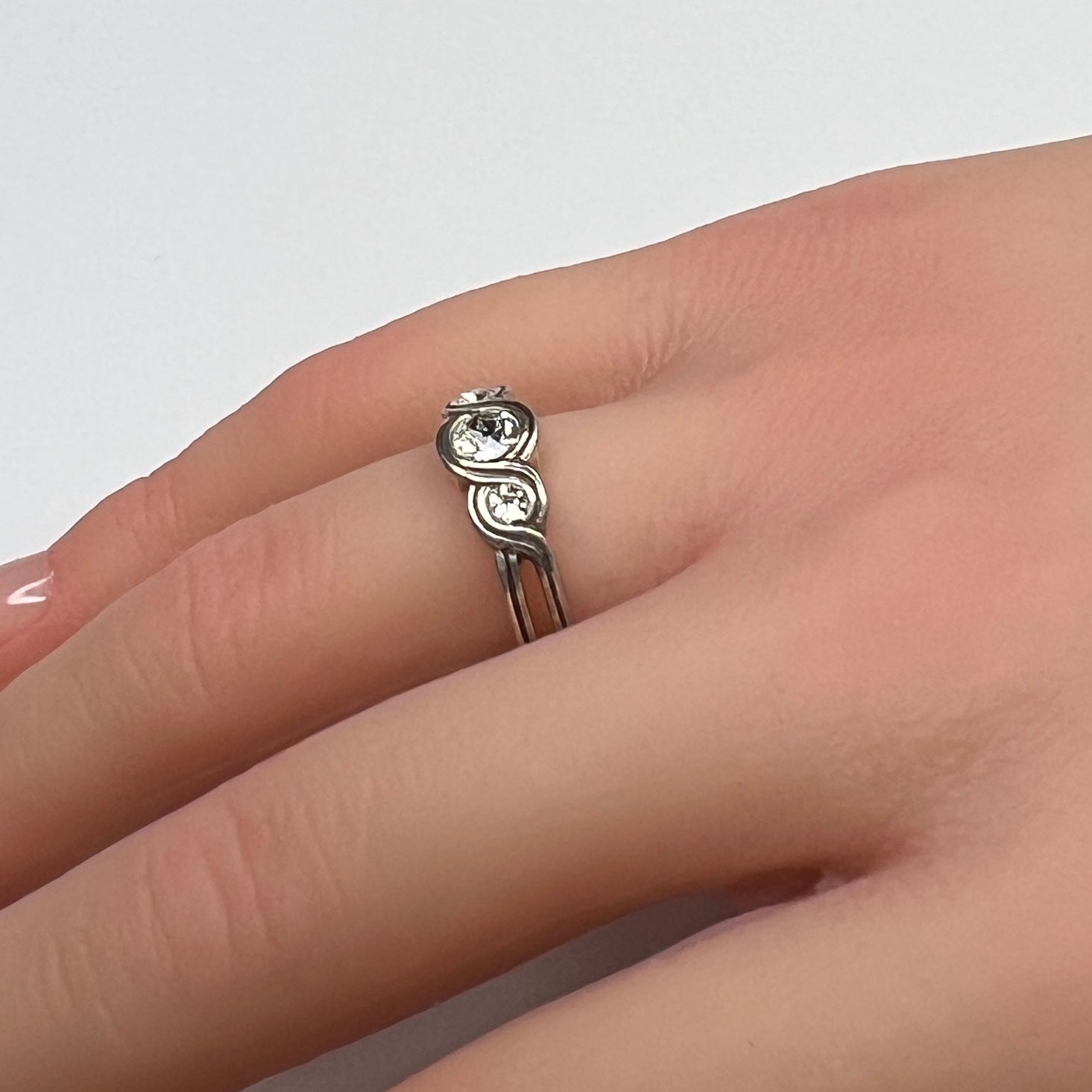 Sterling silver Brighton Infinity ring on hand with three bezel-set crystals