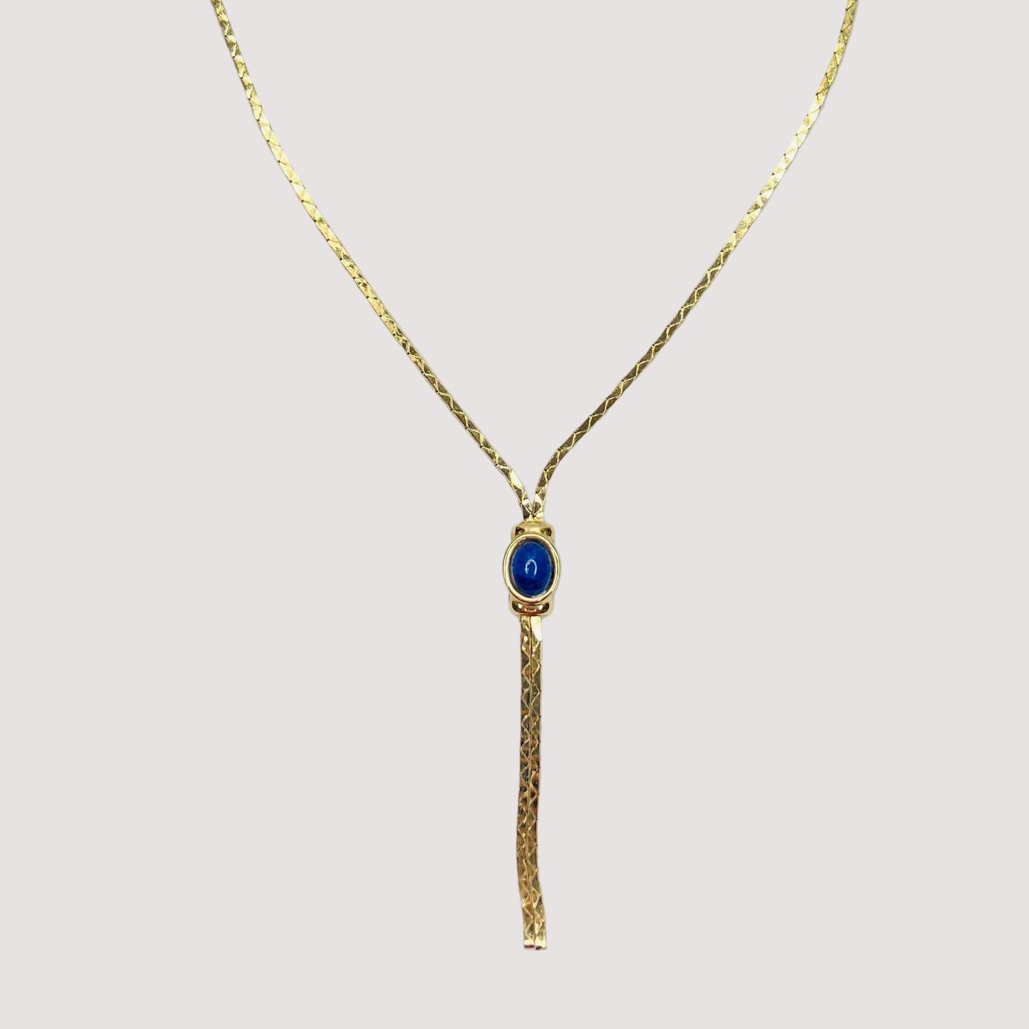 Full view of necklace with lariat drop and blue stone on white background