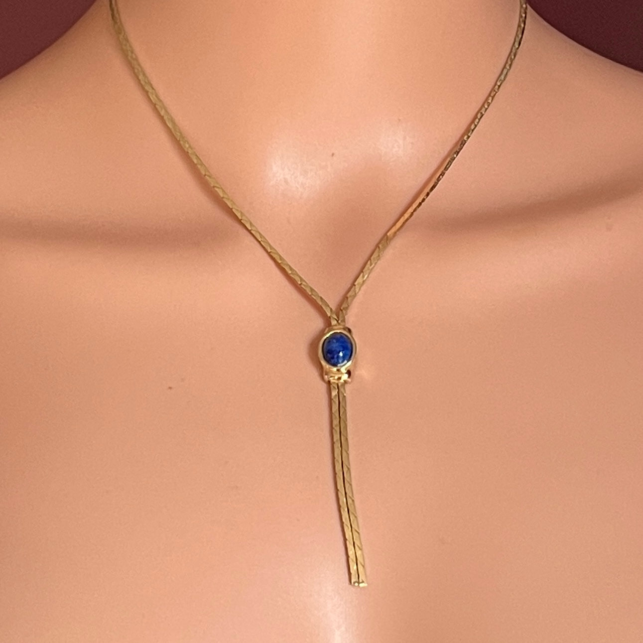 Model wearing 1980s Christian Dior gold Y-necklace with blue cabochon