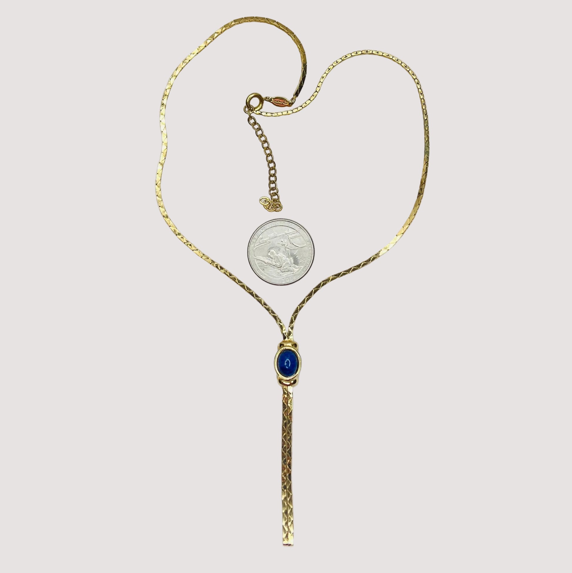 Full view of necklace with lariat drop and blue stone on white background