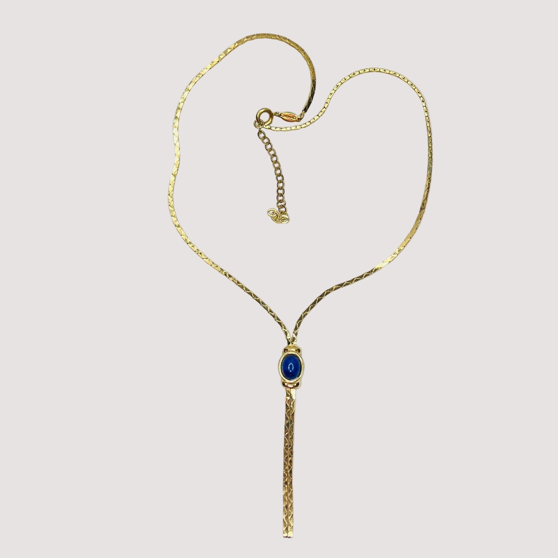 Full view of necklace with lariat drop and blue stone on white background
