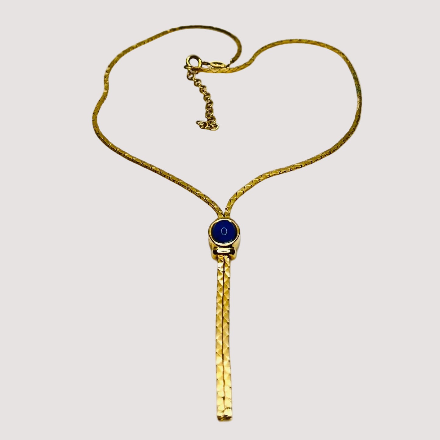 Full view of necklace with lariat drop and blue stone on white background