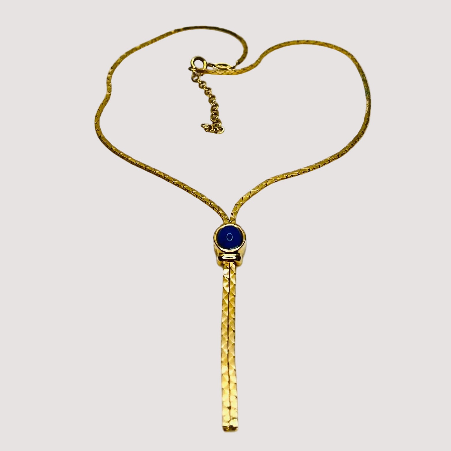 Full view of necklace with lariat drop and blue stone on white background
