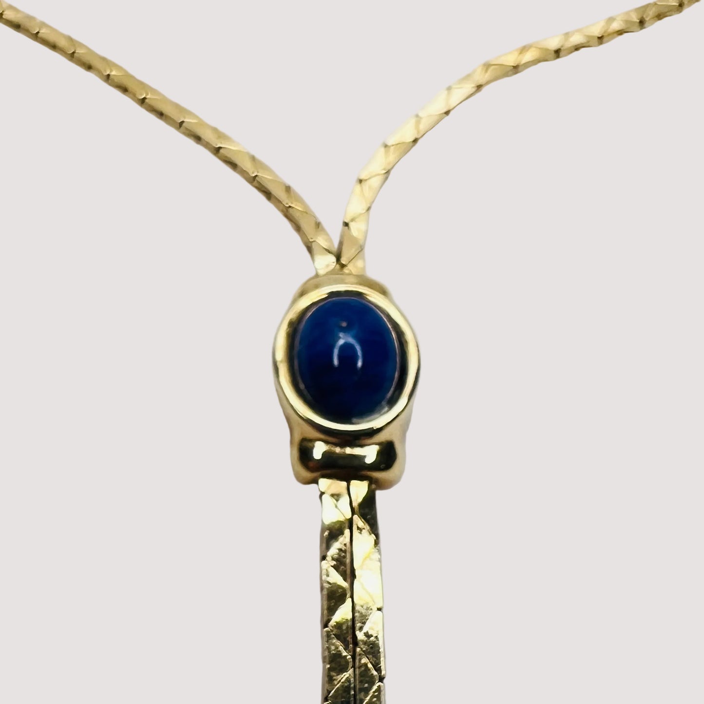 Close-up of oval blue cabochon and drop detail