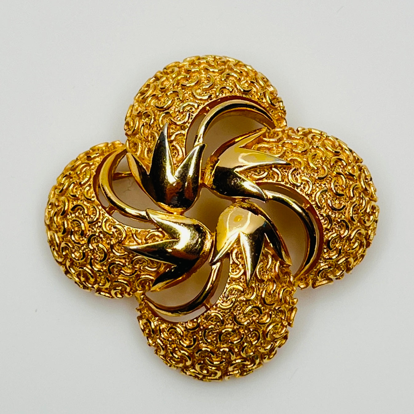 Crown Trifari gold swirl brooch with clover-style textured domes