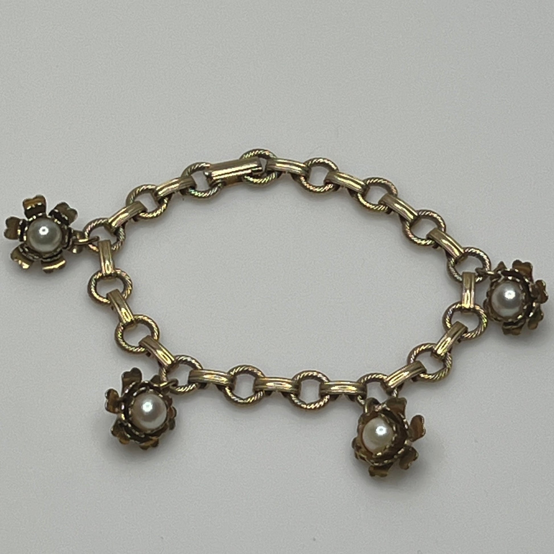 Vintage floral charm bracelet with textured links and pearl accents