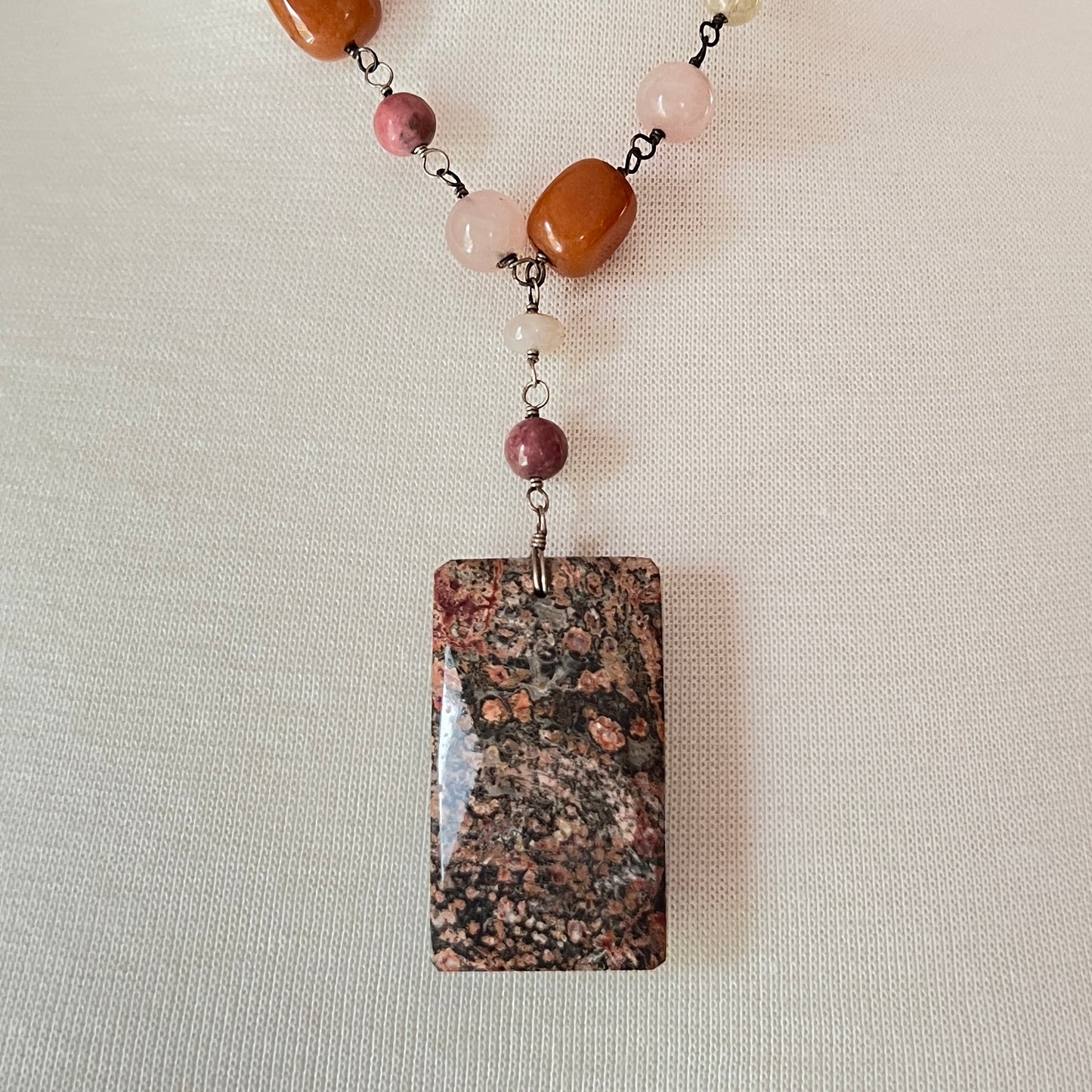 Close-up of rectangular granite pendant with mixed gemstone beads