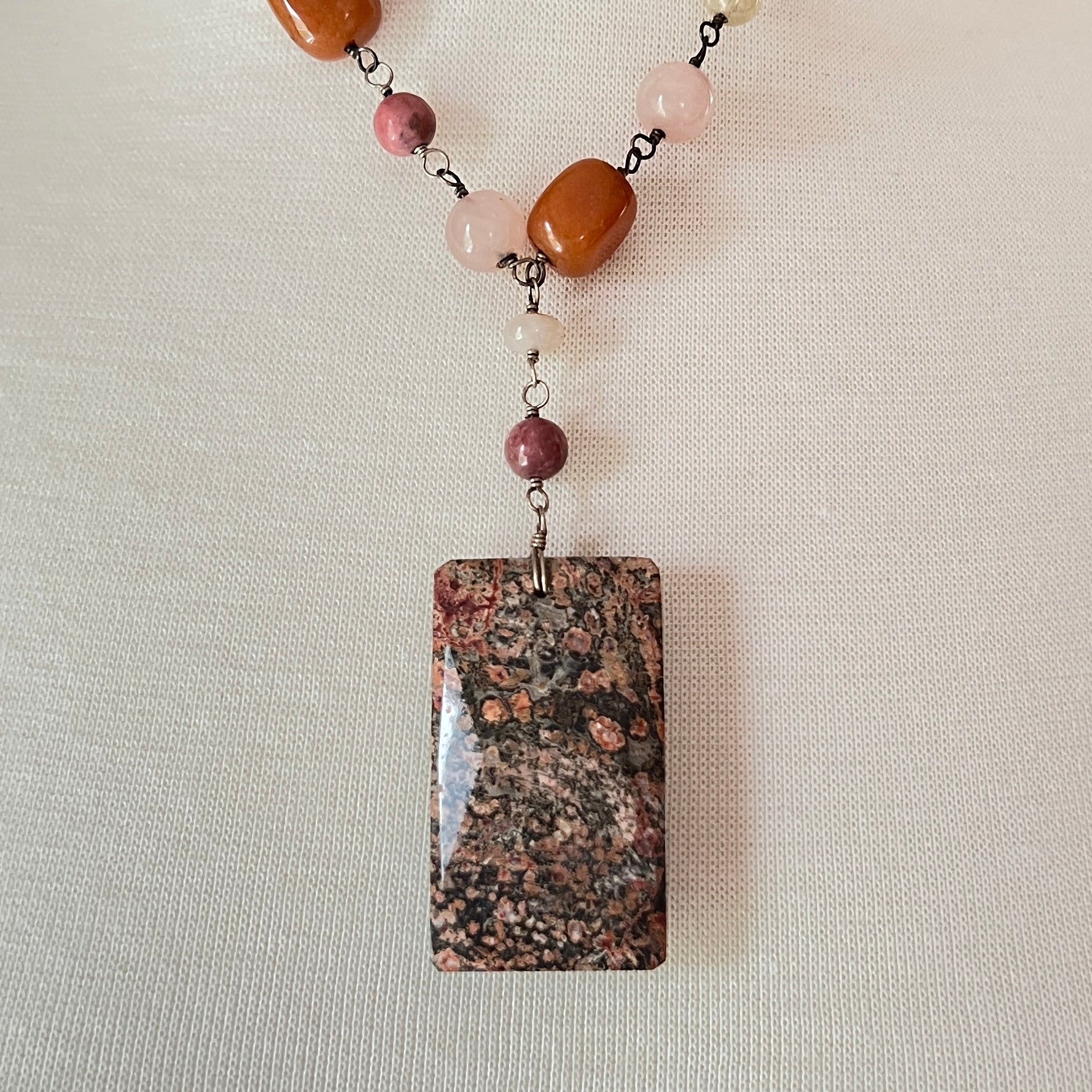 Close-up of rectangular granite pendant with mixed gemstone beads