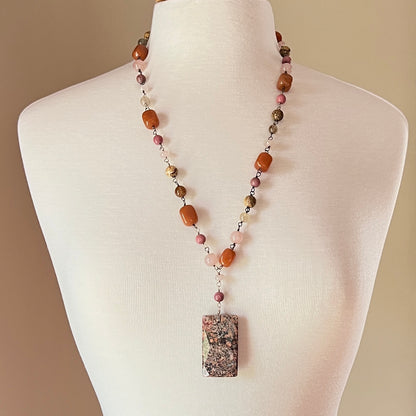 Long beaded gemstone necklace with granite pendant on mannequin bust
