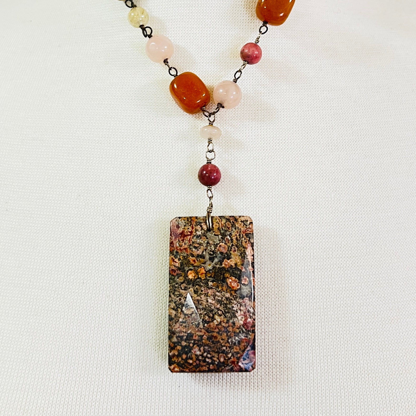 Close-up of rectangular granite pendant with mixed gemstone beads
