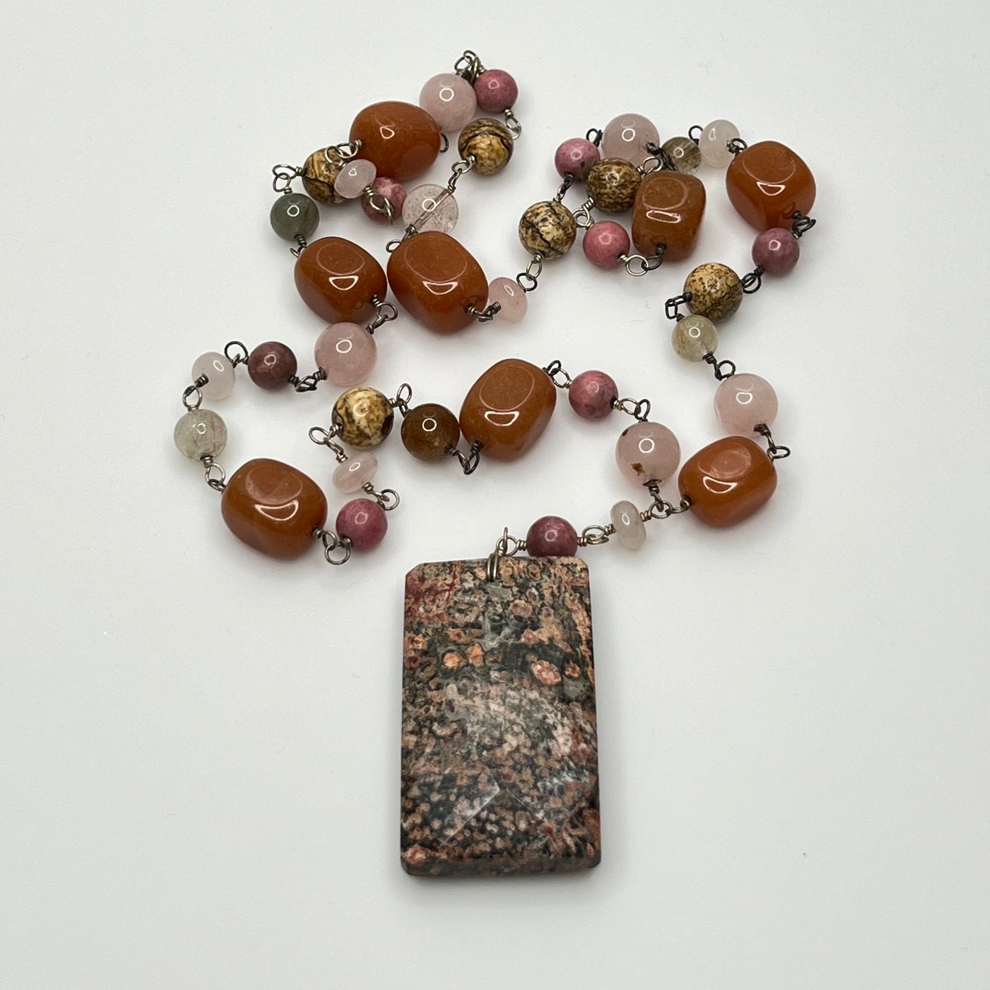 Close-up of rectangular granite pendant with mixed gemstone beads