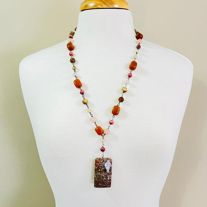 Long beaded gemstone necklace with granite pendant on mannequin bust