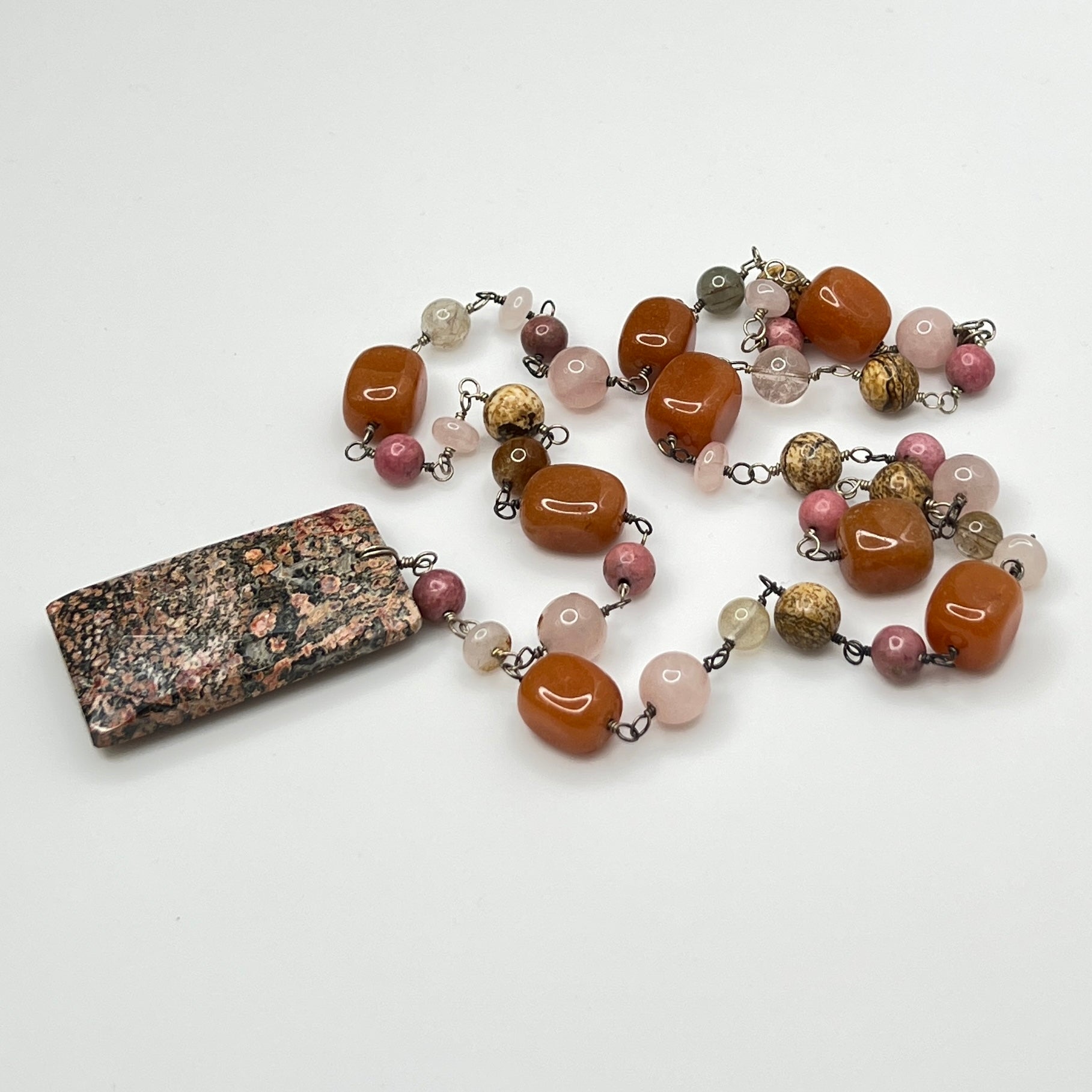 Close-up of rectangular granite pendant with mixed gemstone beads