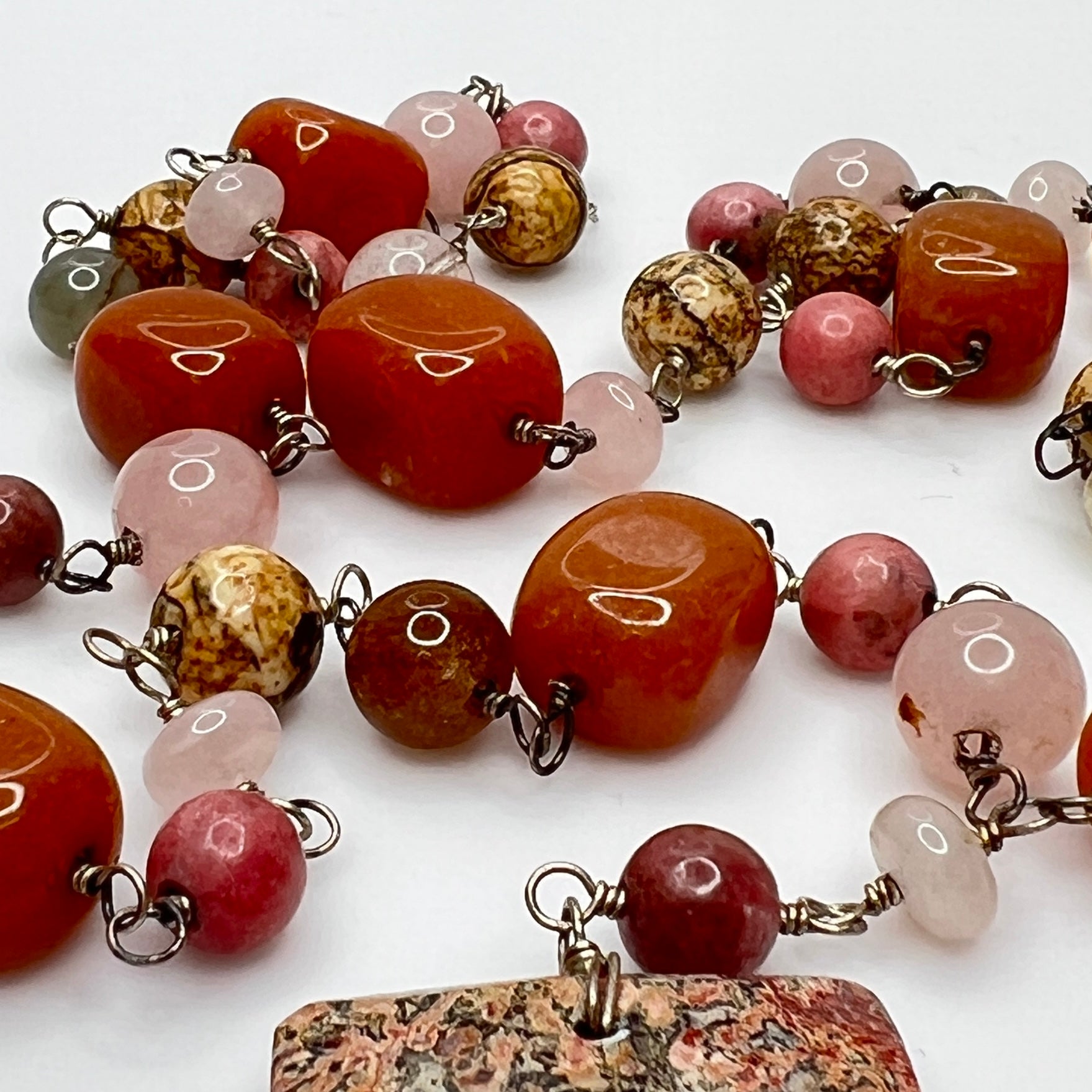 Close-up of rectangular granite pendant with mixed gemstone beads