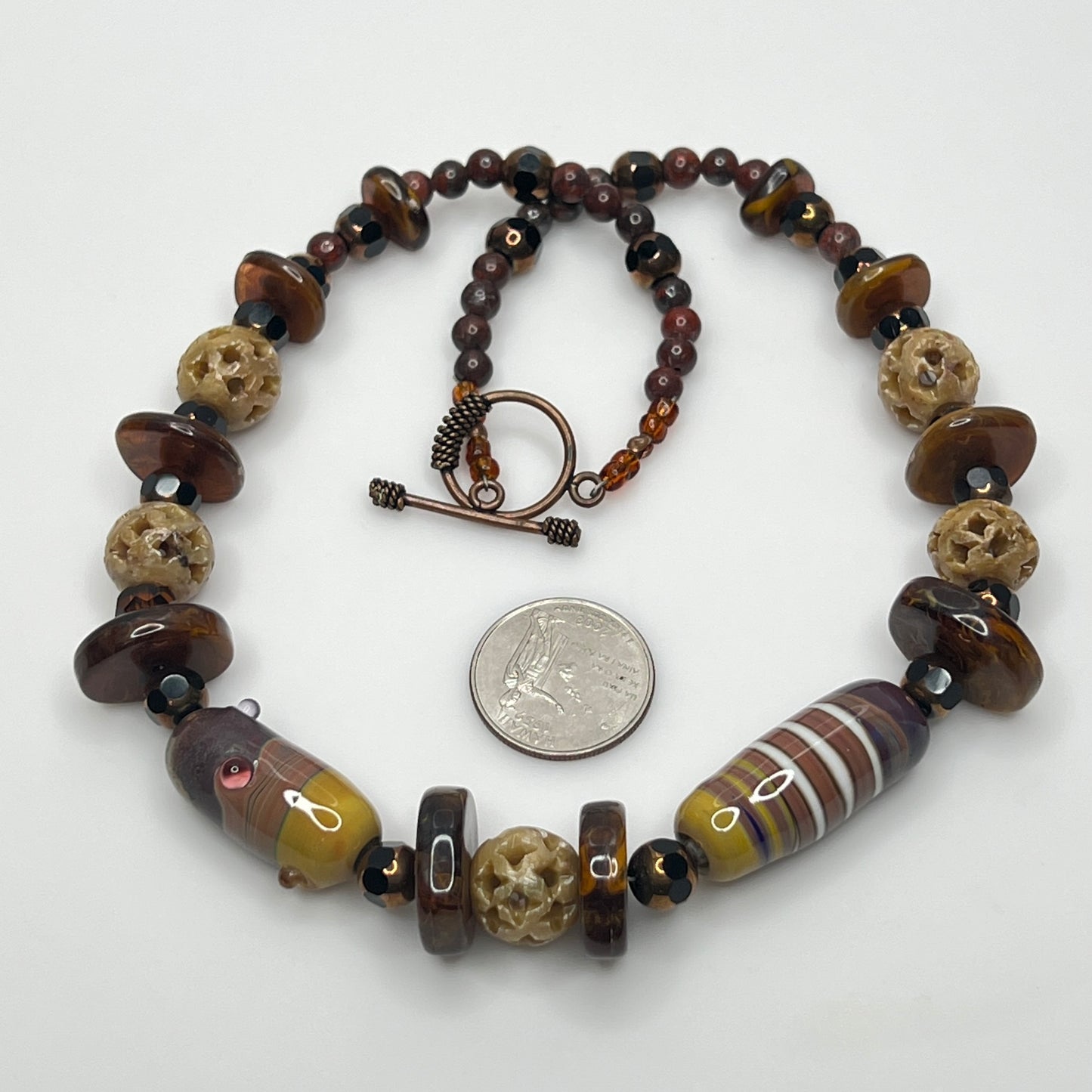 Vintage necklace with glass and carved stone beads in warm earthy tones