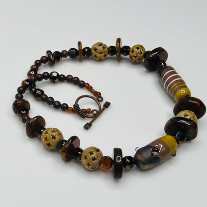 Vintage necklace with glass and carved stone beads in warm earthy tones