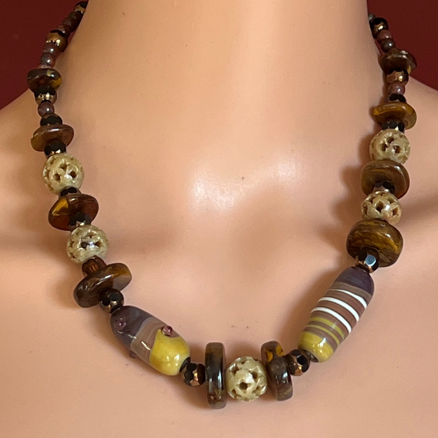 Vintage necklace with glass and carved stone beads in warm earthy tones