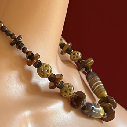 Vintage necklace with glass and carved stone beads in warm earthy tones