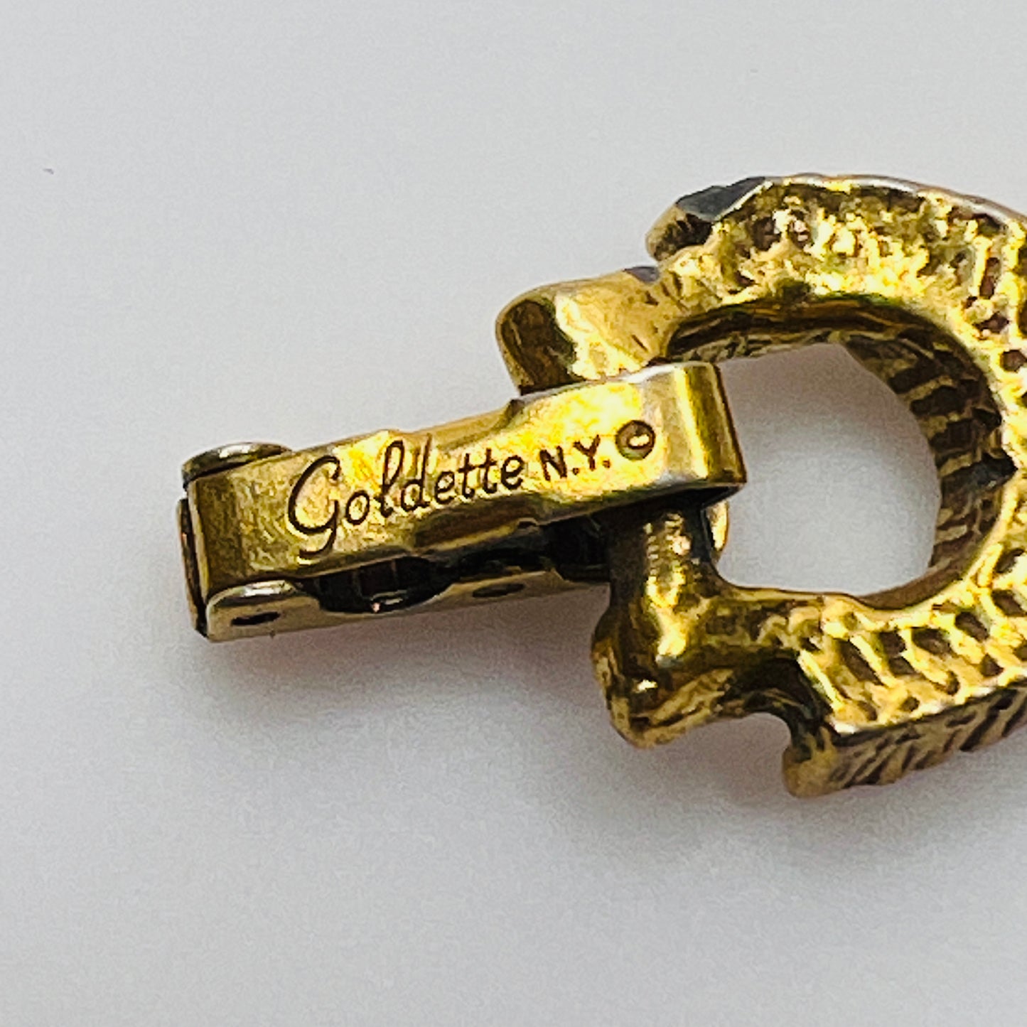 Filigree bracelet with varied gemstone details laid flat, fold-over clasp visible