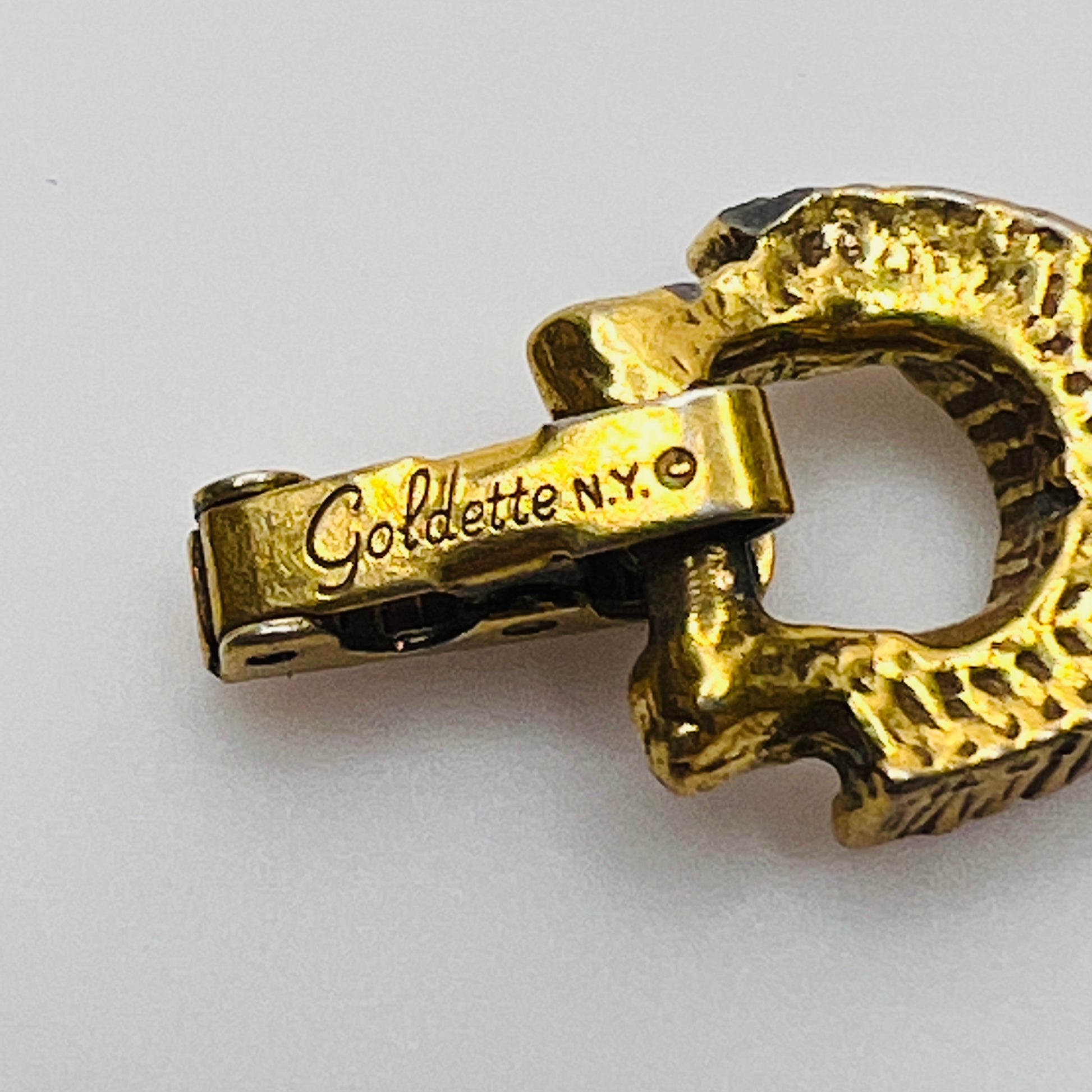 Filigree bracelet with varied gemstone details laid flat, fold-over clasp visible