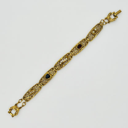 Filigree bracelet with varied gemstone details laid flat, fold-over clasp visible