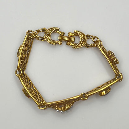 Filigree bracelet with varied gemstone details laid flat, fold-over clasp visible