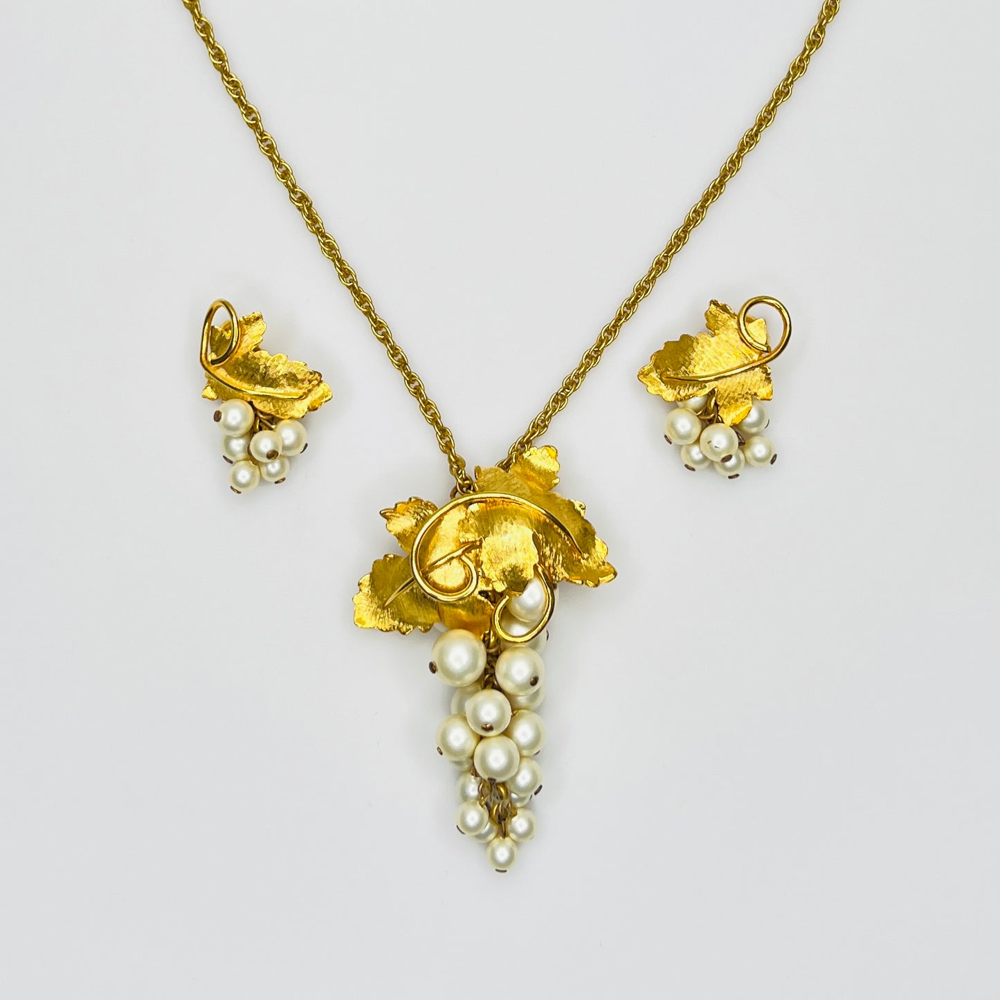 Close-up of 1950s faux pearl grape cluster clip-on earrings and convertible pendant