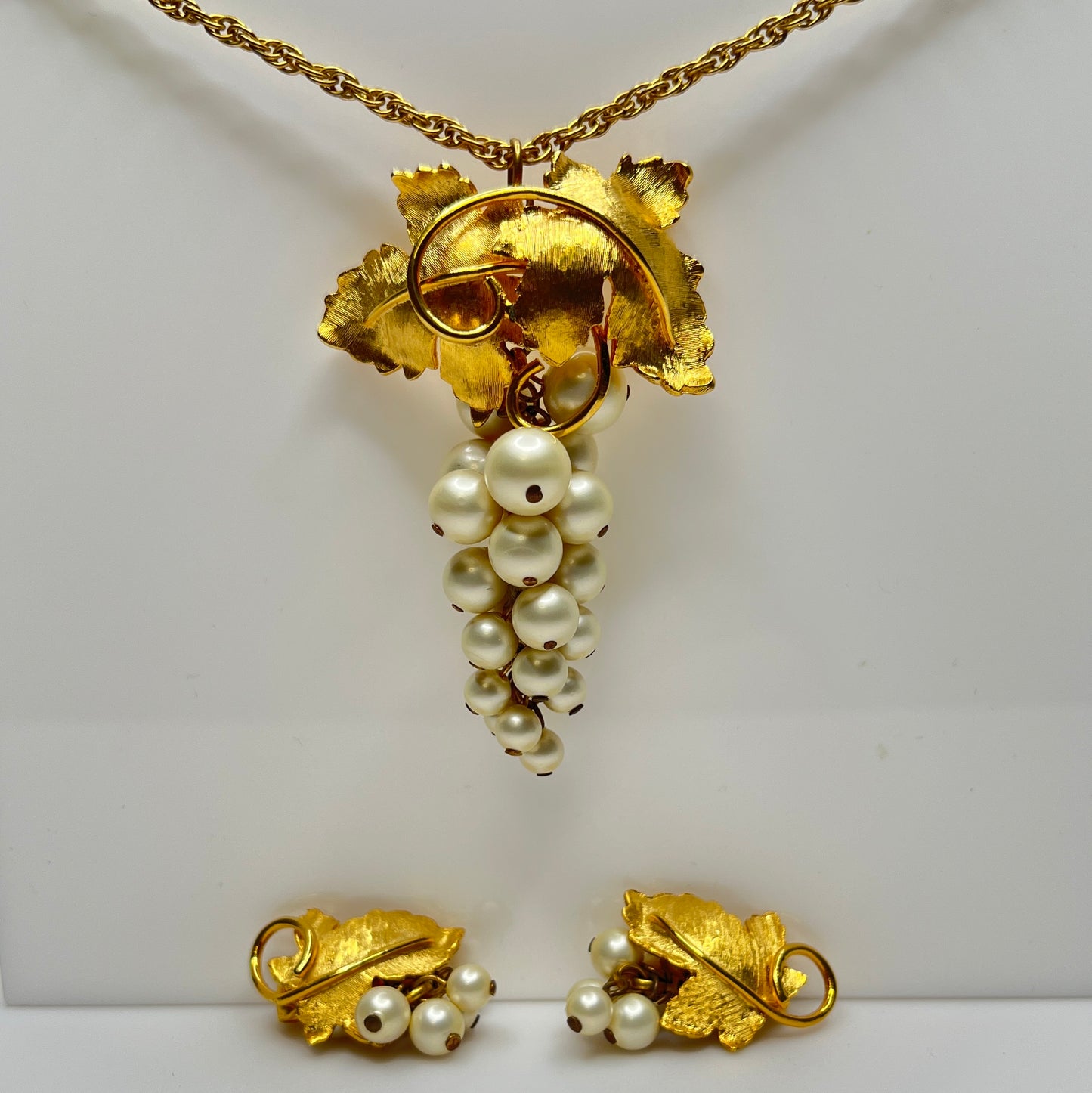 Close-up of 1950s faux pearl grape cluster clip-on earrings and convertible pendant