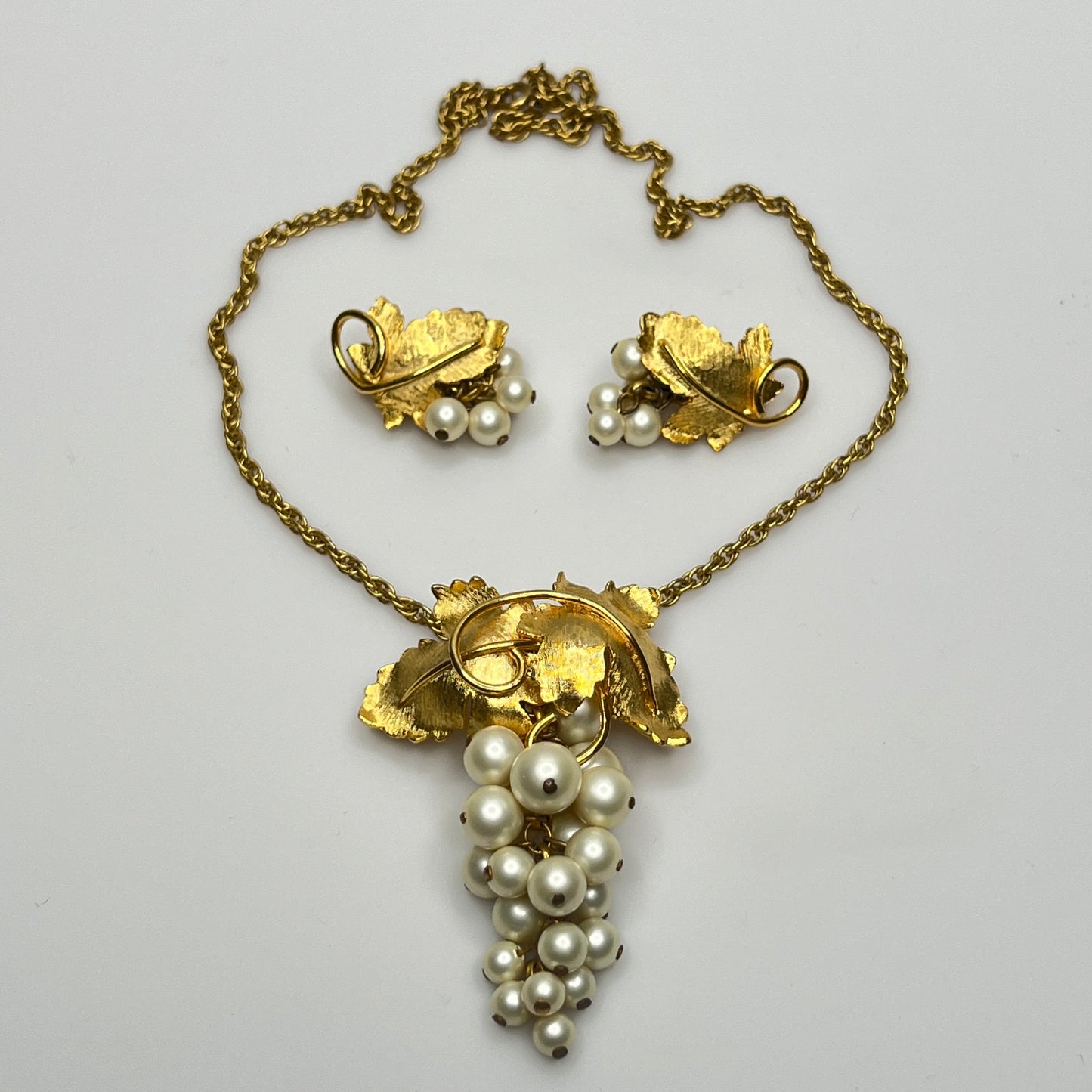 Close-up of 1950s faux pearl grape cluster clip-on earrings and convertible pendant