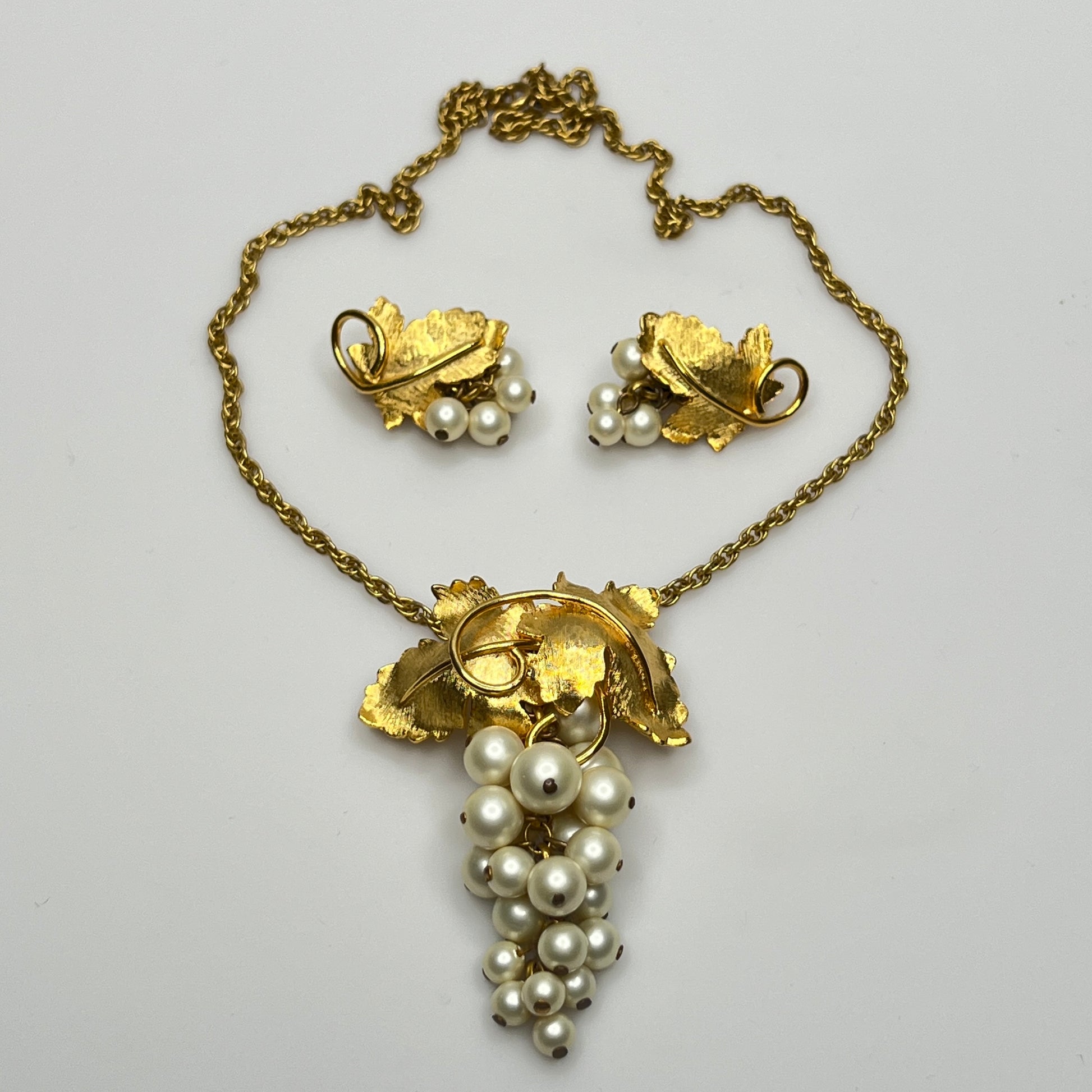 Close-up of 1950s faux pearl grape cluster clip-on earrings and convertible pendant