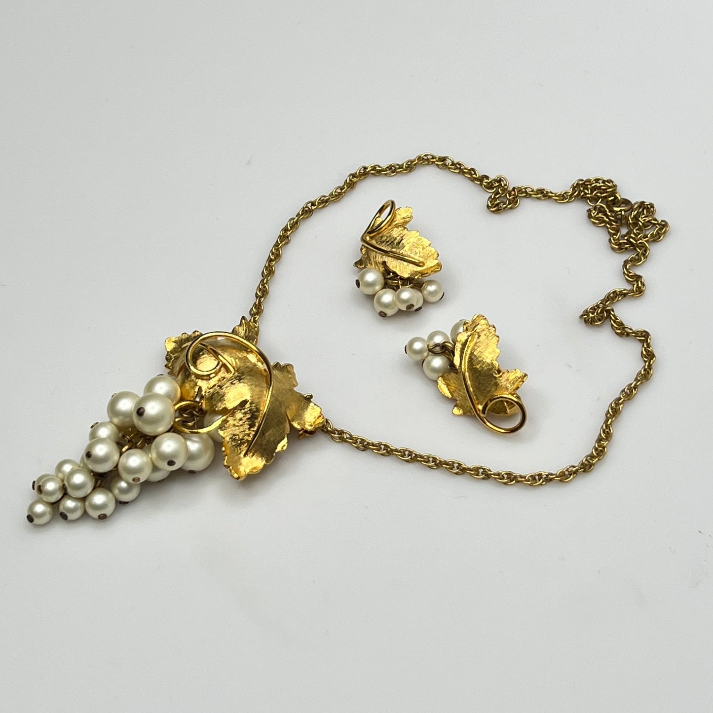Close-up of 1950s faux pearl grape cluster clip-on earrings and convertible pendant