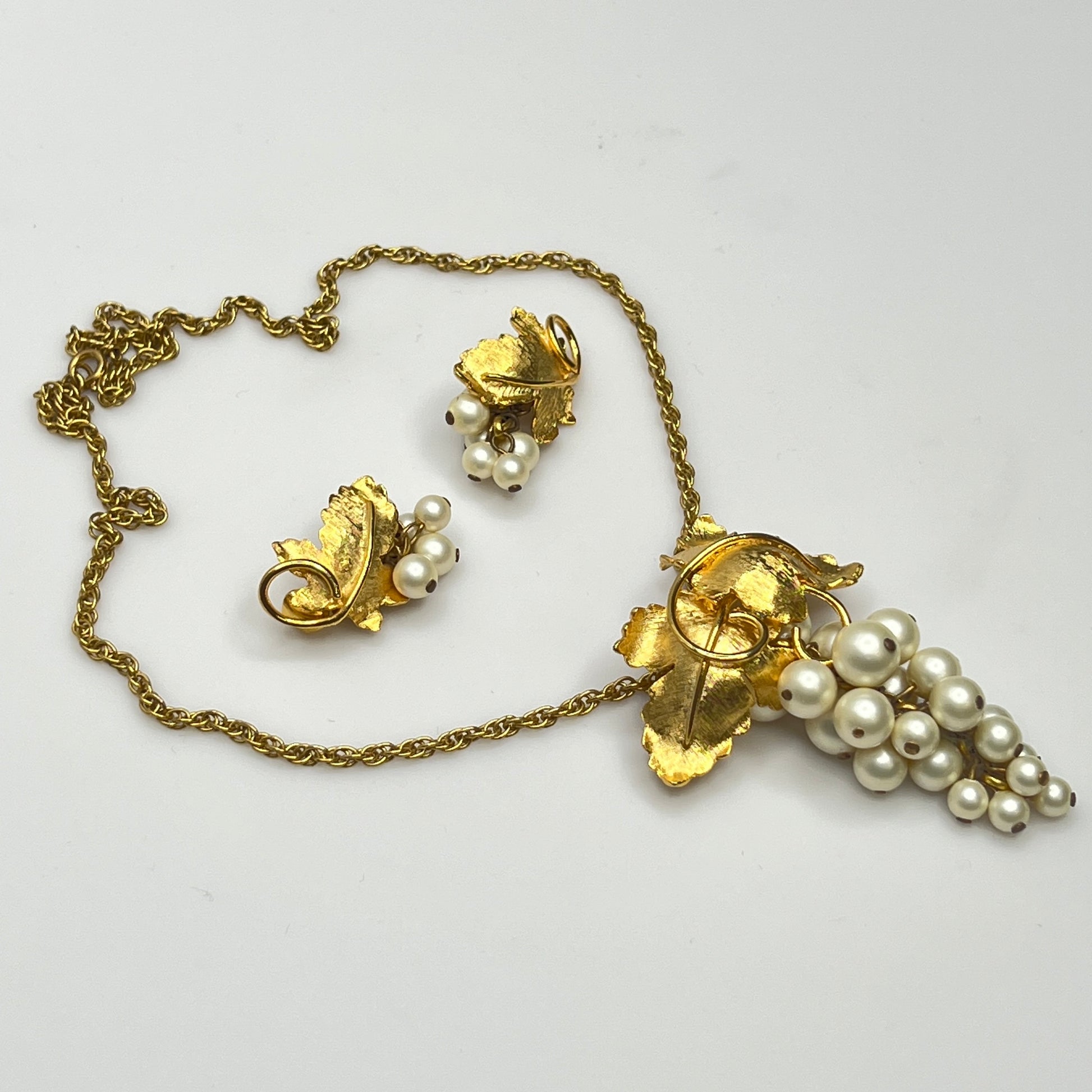 Close-up of 1950s faux pearl grape cluster clip-on earrings and convertible pendant