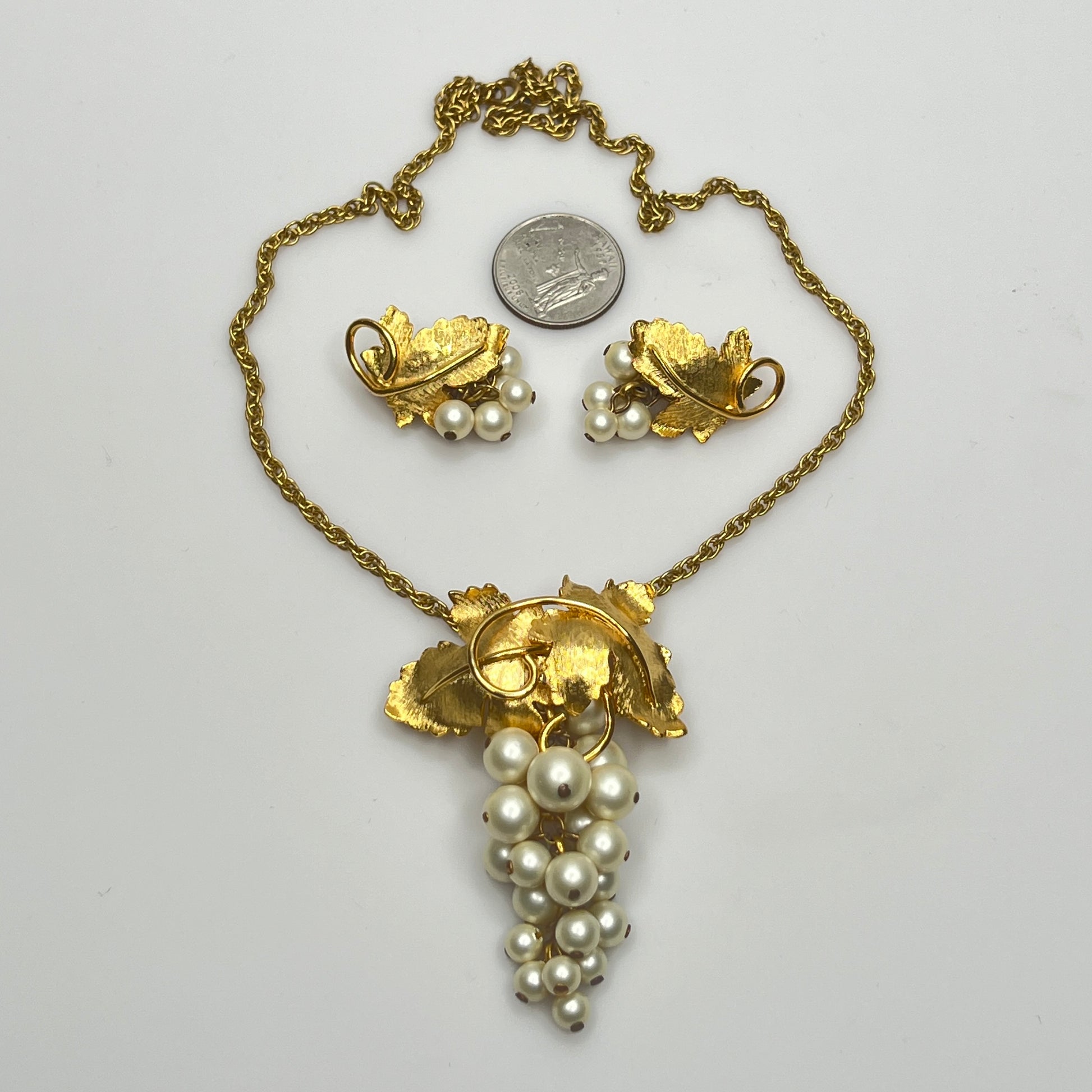 Close-up of 1950s faux pearl grape cluster clip-on earrings and convertible pendant
