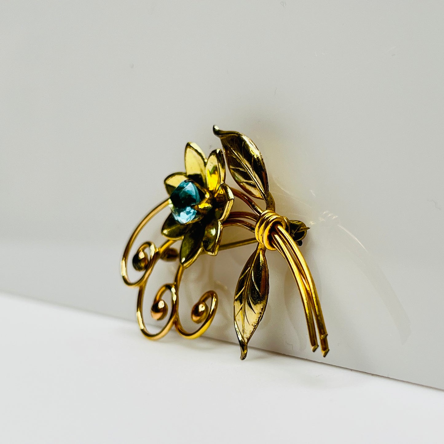 Vintage gold-filled floral brooch with blue rhinestone, signed Harry Iskin