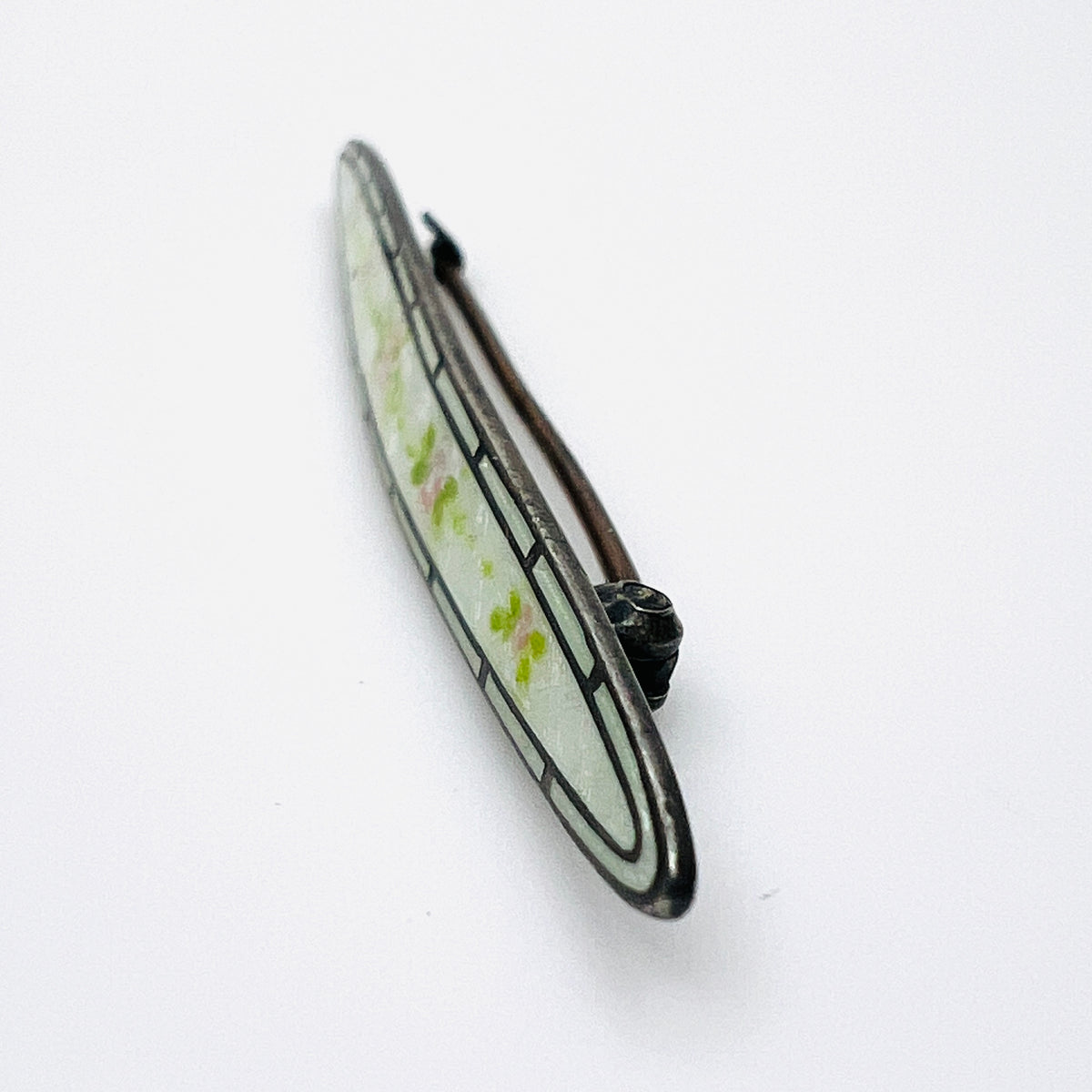 Side view of antique sterling silver enamel brooch showing C-clasp pin